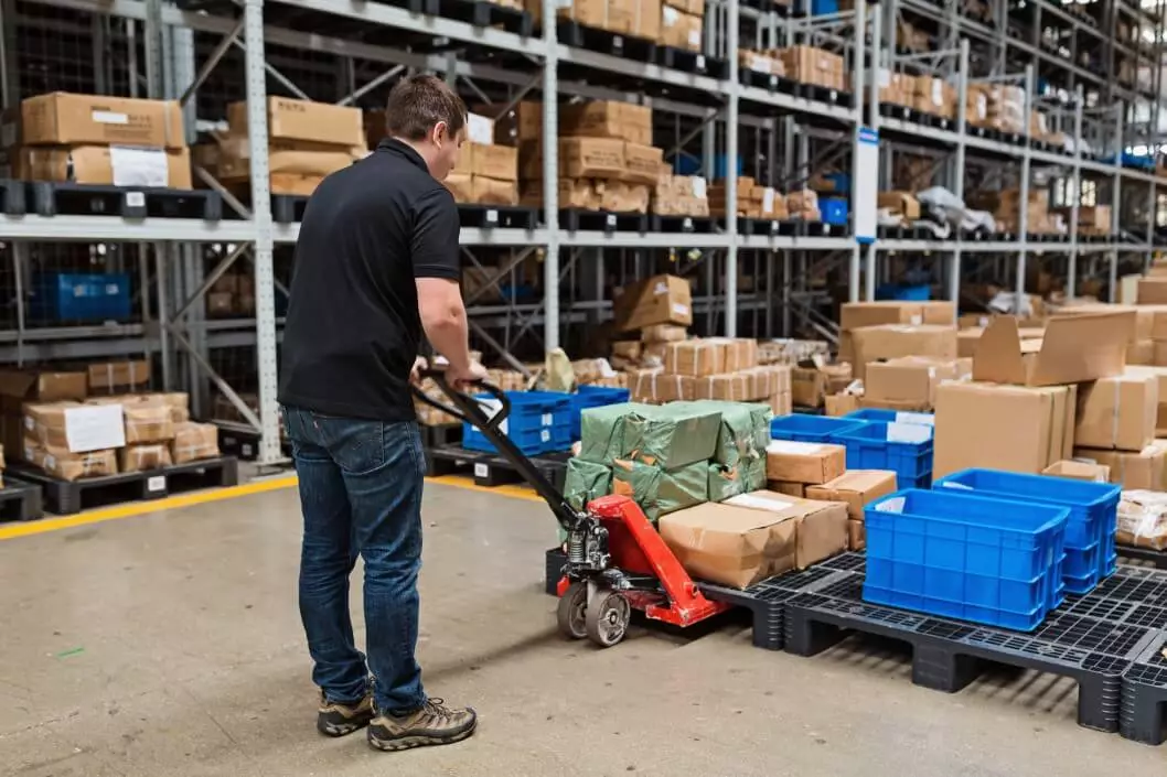 Warehouse worker moving goods with a pallet jack